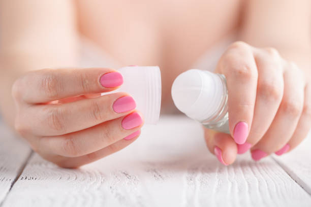 A woman opening a roll-on deodorants