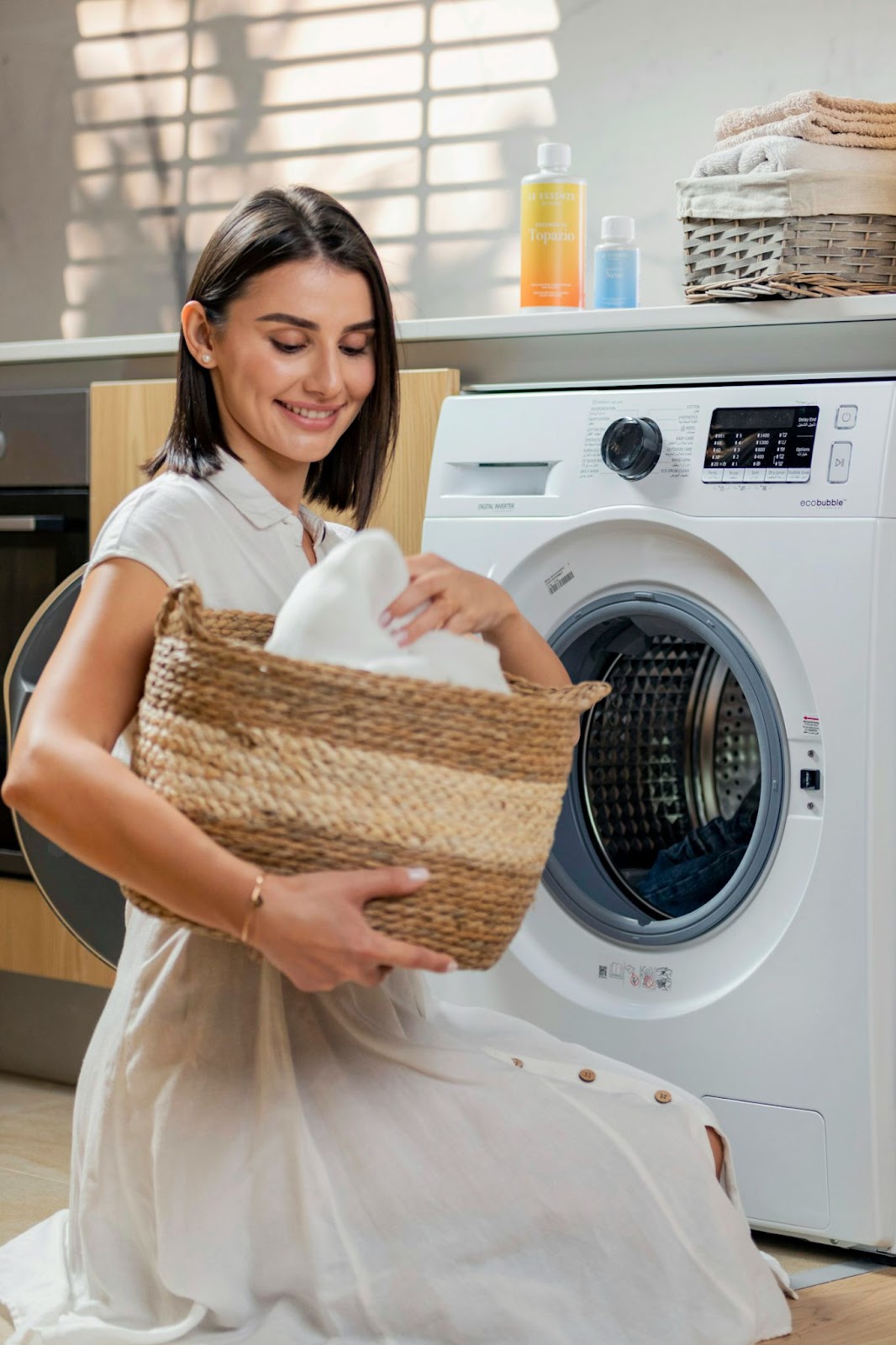 A woman putting clothes inside a washing machine
