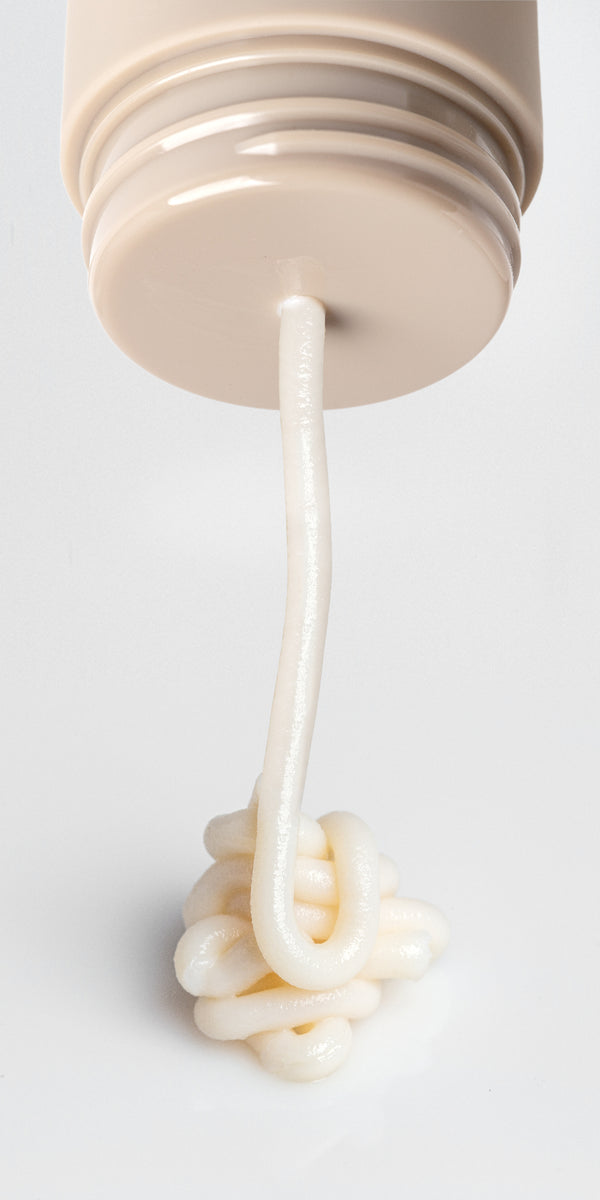 Roon's whipped balm dispensing in a long ribbon from the twist-up tube, showing the dense waterless texture